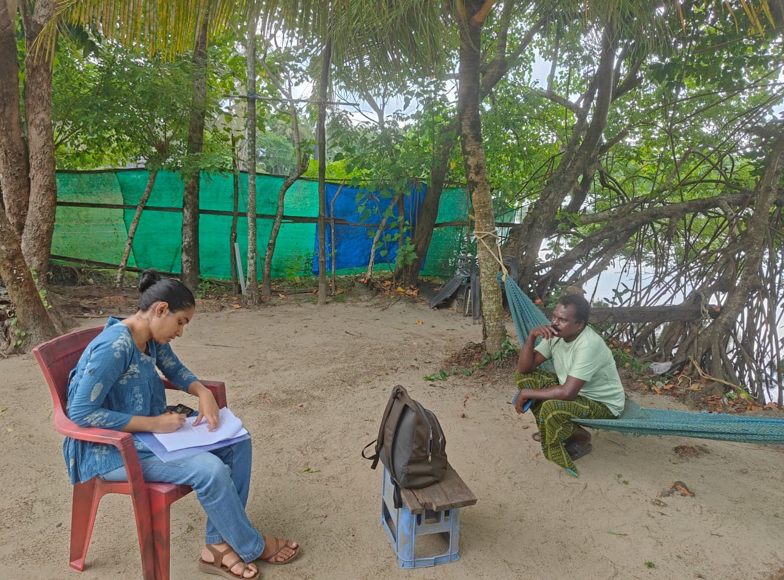 A researcher notes a resident's answers during the household survey on Lanka Thuruth